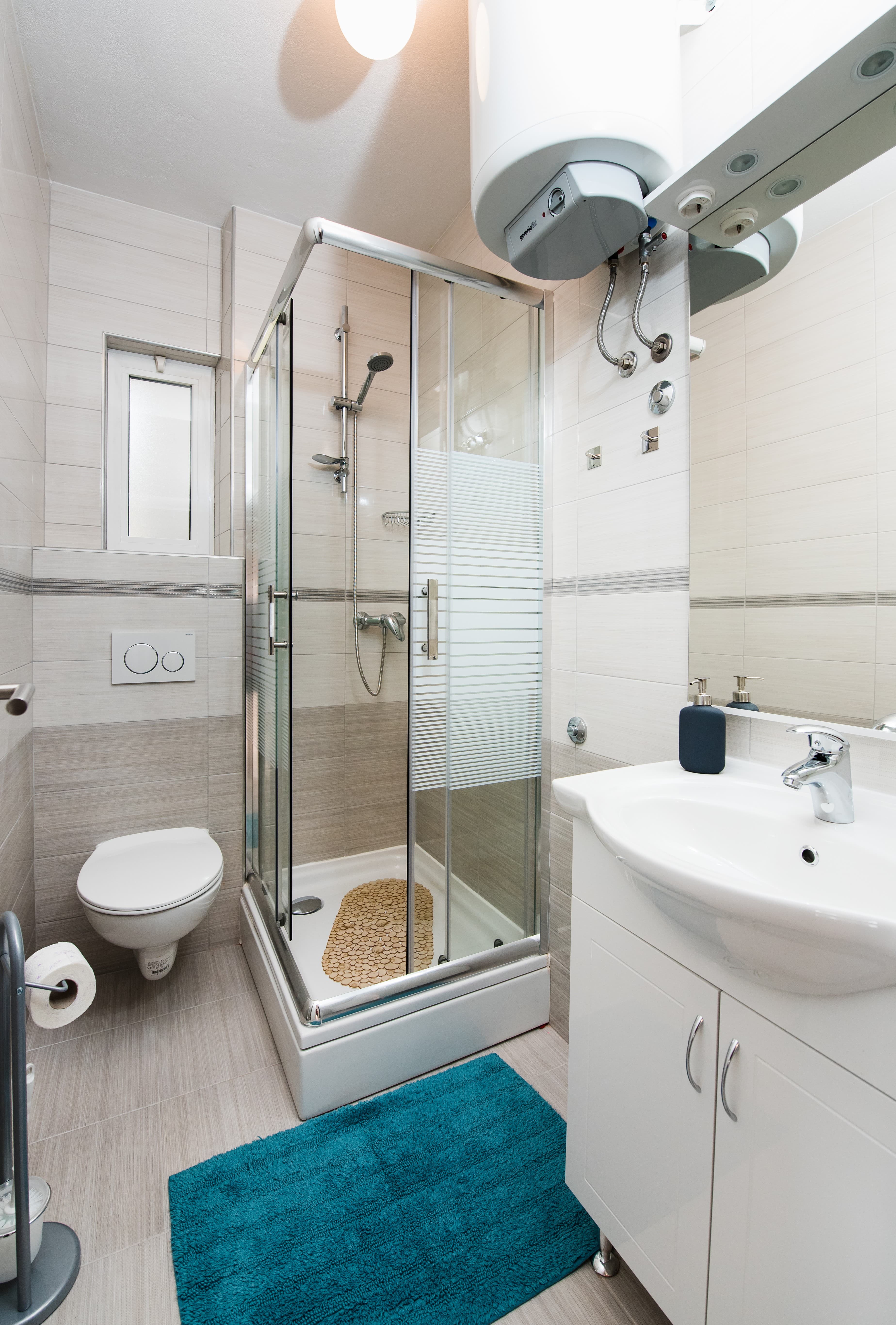 Modern bathroom with glass shower and beige tiles